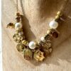 Collier doré avec ses perles blanches et ses breloques dorées